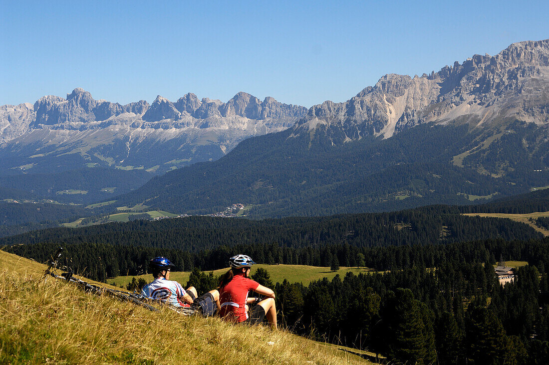 Couple having a rest, mountainbike tour, MTB, Rosengarten Mountain Range, Dolomiten, South Tyrol, Italy, Europe