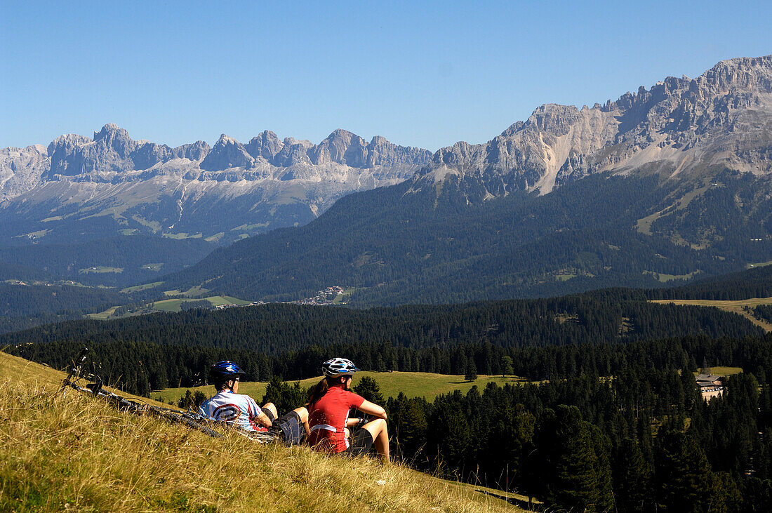 Paar beim Rasten MTB Mountainbike Tour in den Dolomiten, Rosengartengruppe, Dolomiten, Südtirol, Italien, Europa