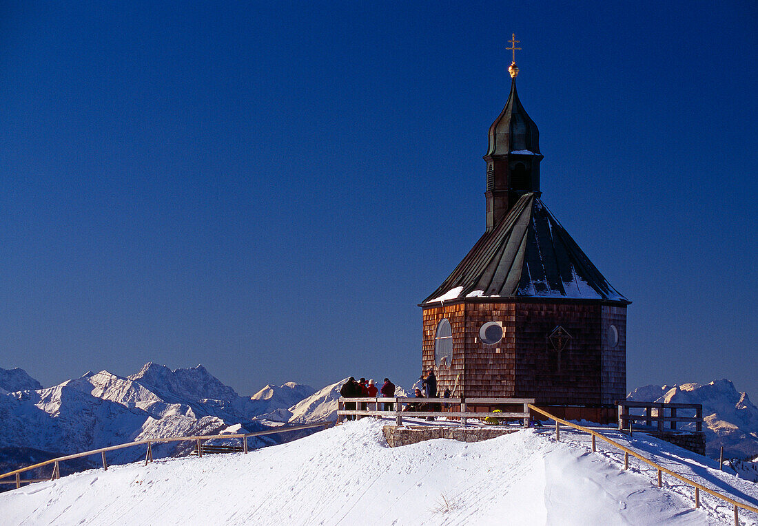 Kapelle auf dem schneebedeckten Wallberg unter blauem Himmel, Bayern, Deutschland, Europa