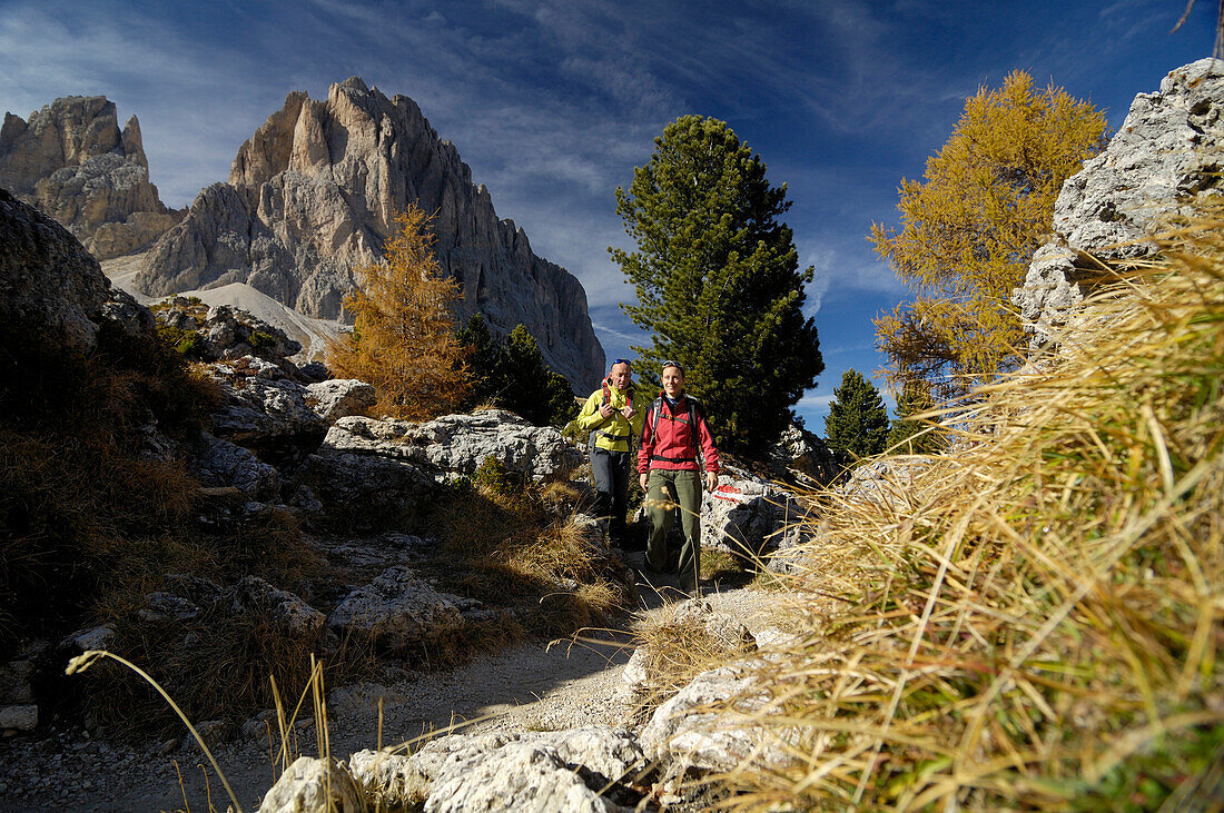 Wanderer mit Rucksäcken zwischen Felsen im Sonnenlicht, Grödnertal, Dolomiten, Südtirol, Italien, Europa