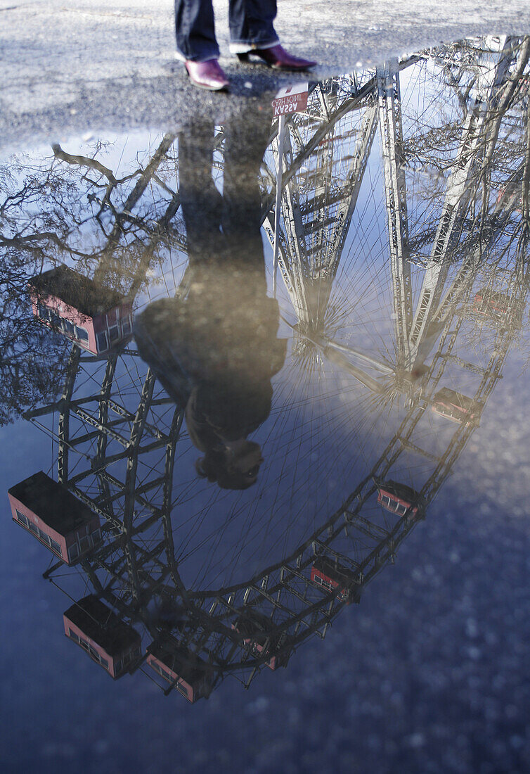 Reflection of a woman on puddle surface, Prater, Vienna, Austria