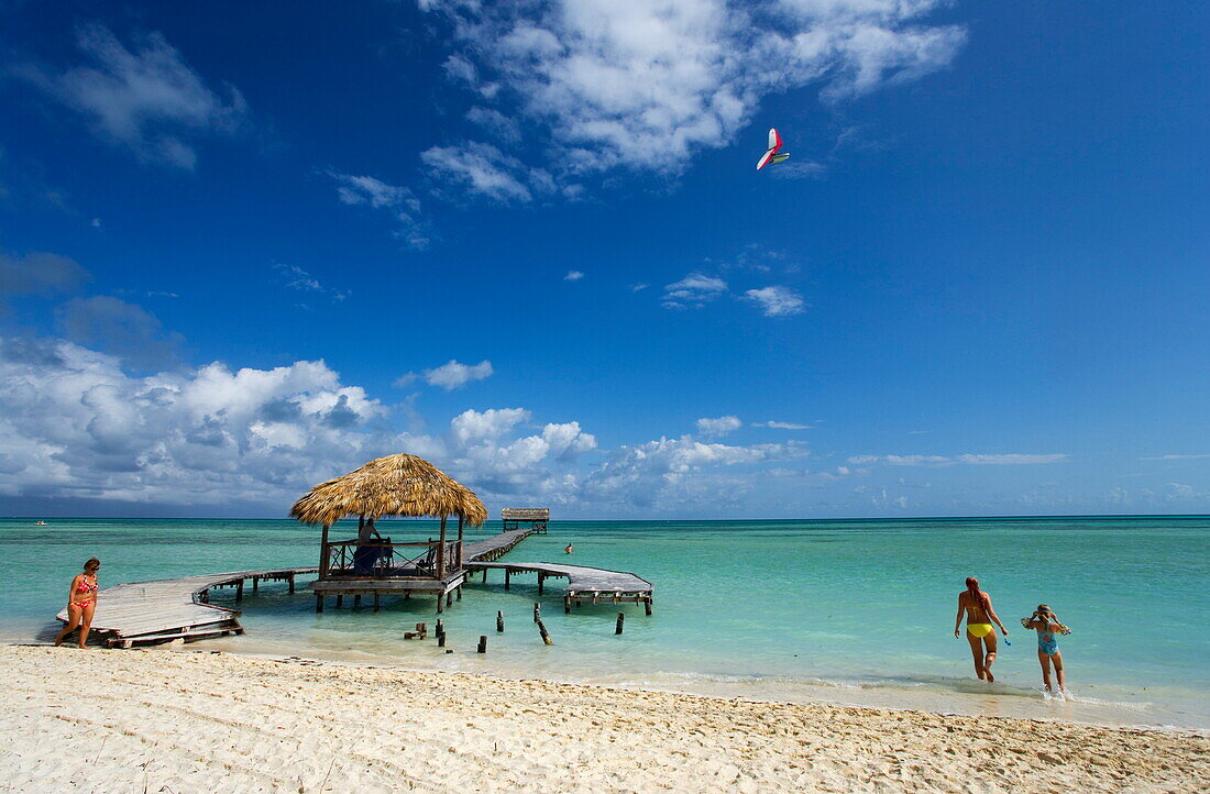 Tourists near jetty at sandy beach, Cayo Guillermo, Ciego de Avila, Cuba, West Indies