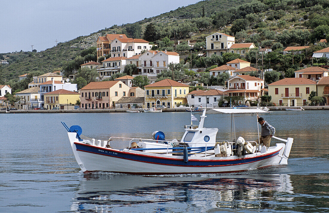Boat moving in harbour and Vathi town behind, Vathi, Ithaca, Greece