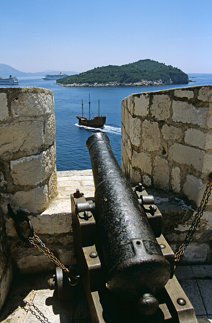 Looking along barrel of cannon toward passing galleon and Lokrum Island, from old city walls, Dubrovnik, Dalmatian Coast, Croatia, Former Yugoslavia