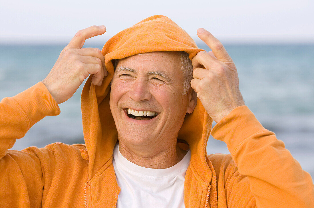 Adult, Adults, beach, beaches, Caucasian, Caucasians, Color, Colour, Contemporary, Daytime, exterior, Exuberance, Exuberant, Gesture, Gestures, Gesturing, Gray-haired, Grey hair, Grey haired, Grey hairs, Grey-haired, grin, grinning, happiness, happy, Head