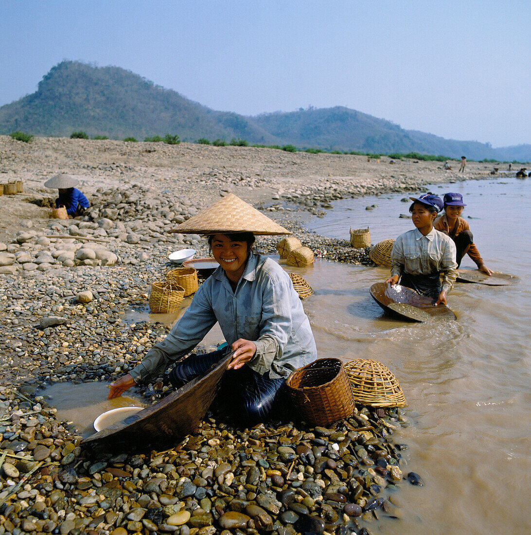 Girls with dishes at pebbly margin of River Mekong., Panning for gold, Luang Prabang Province, Laos