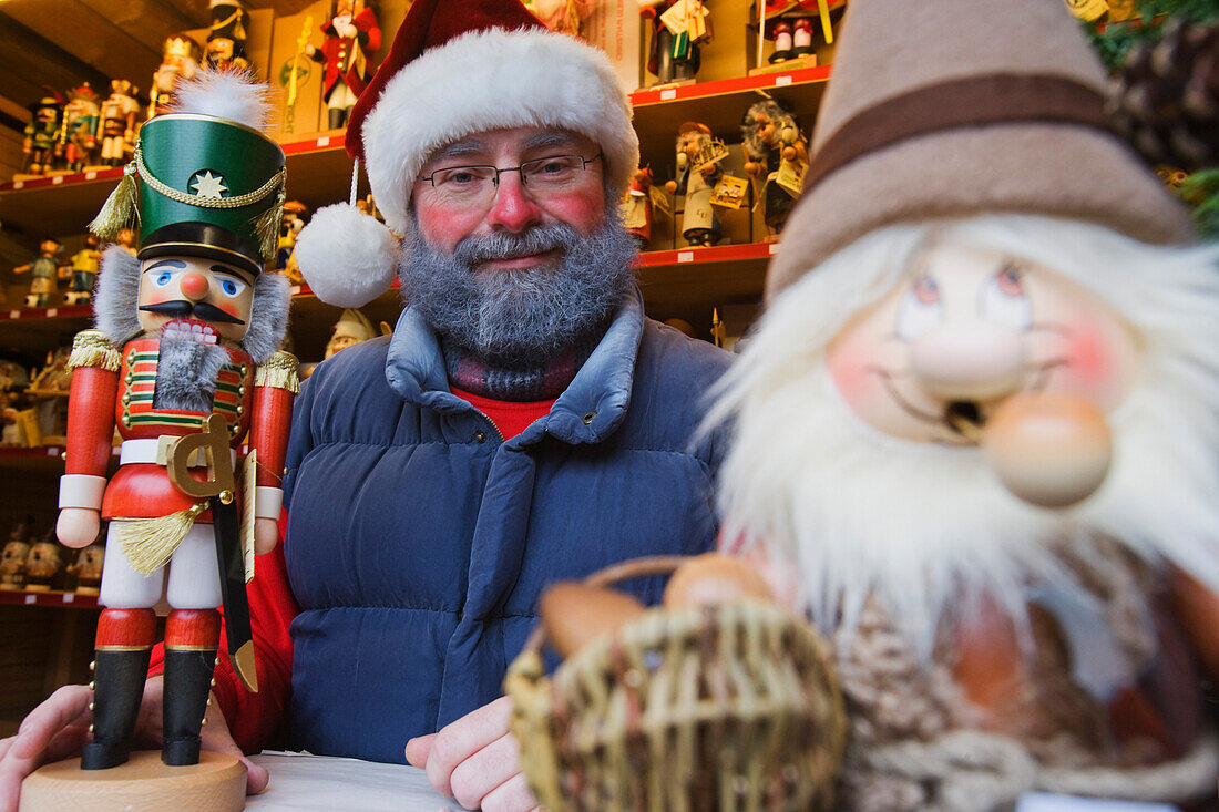 Mann in einem Verkaufsstand auf dem Weihnachtsmarkt, Seiffen, Erzgebirge, Sachsen, Deutschland