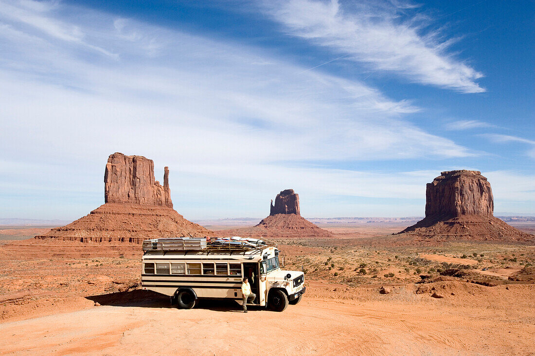 View towards an American Schoolbus with a woman at the entrance door, Monument Valley, Arizona, USA