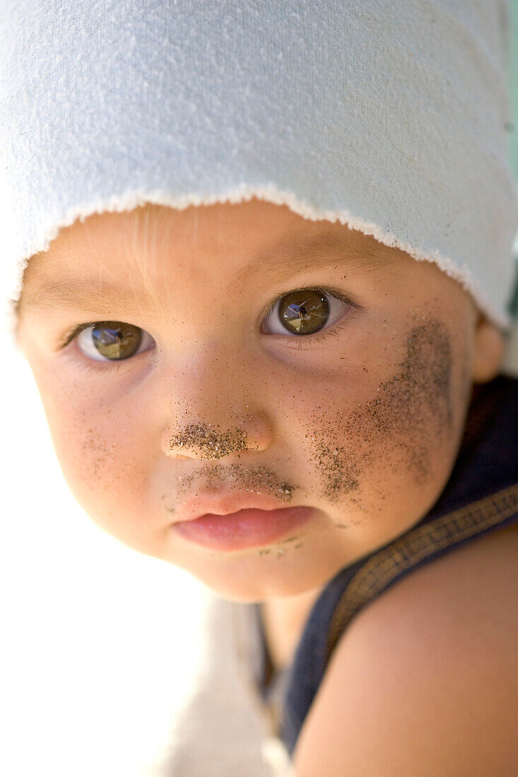 Portrait eines 14 Monate alten Mädchens das im Sand gespielt hat, Punta Conejo, Baja California Süd, Mexiko