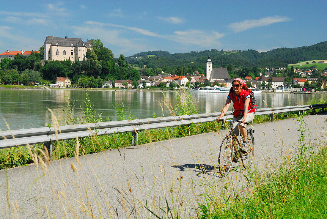 Radfahrerin fährt entlang der Donau, Donauradweg Passau Wien, Grein, Oberösterreich, Österreich