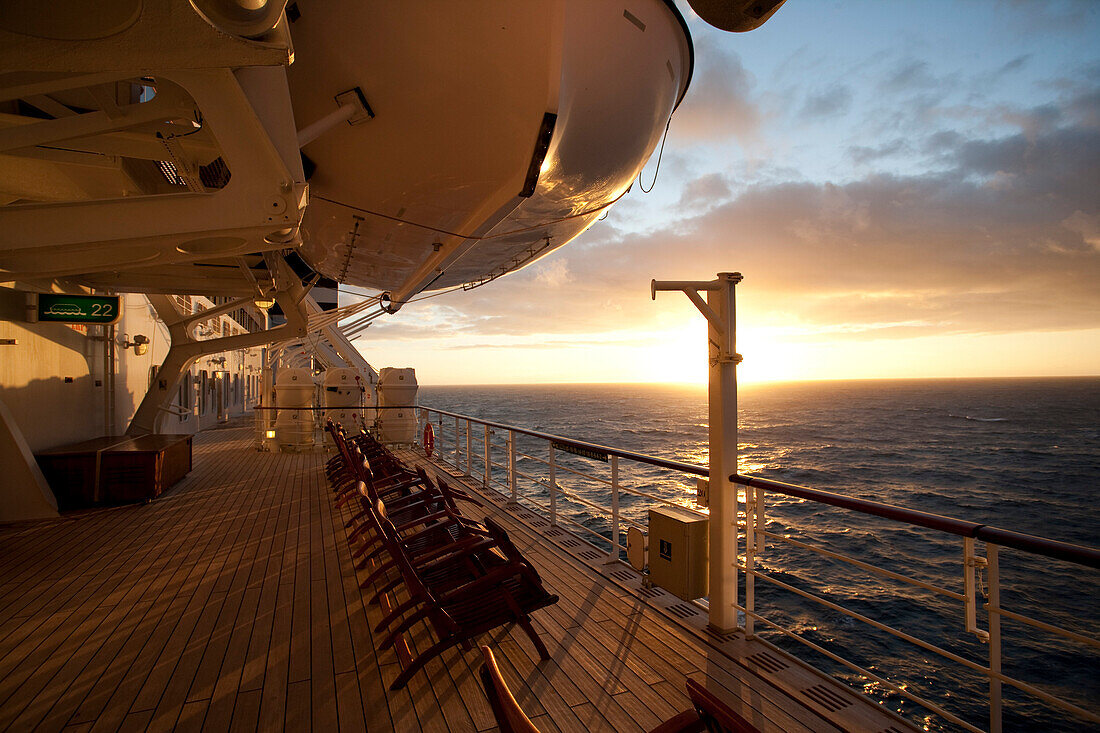 Promenadendeck mit Liegestühle bei Sonnenuntergang, Kreuzfahrtschiff Queen Mary 2, Transatlantik, Nordatlantik, Atlantik