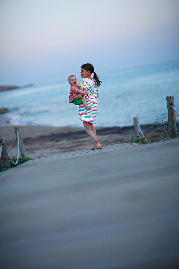 Mädchen mit Baby am Steg, Formentera, Balearen, Spanien