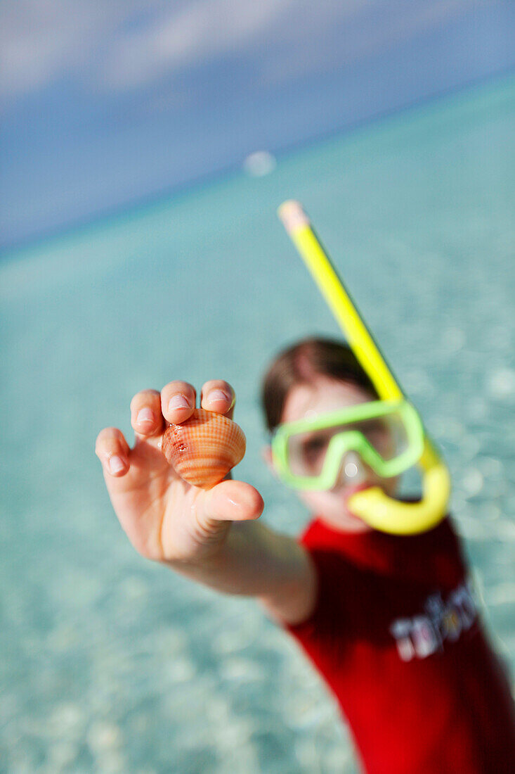 Girl snorkeling in the sea, holding a shell, Formentera, Balearic Islands, Spain