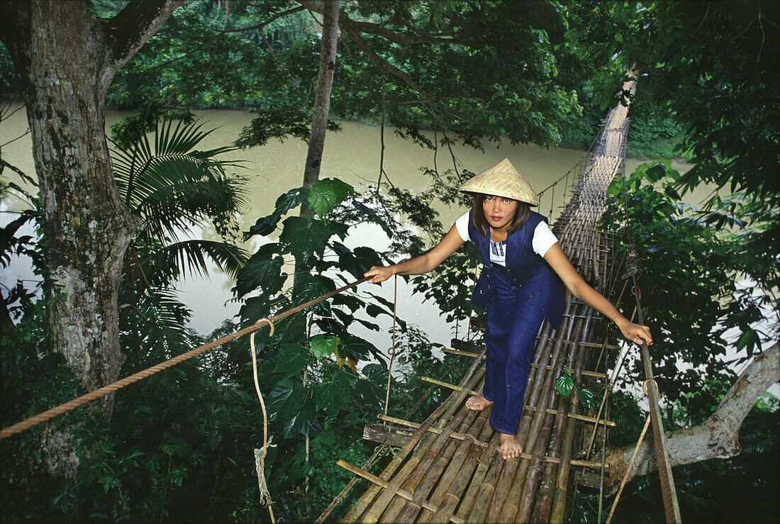 Junge Frau überquert Bambusbrücke über dem Loboc Fluss, Loboc, Bohol, Philippinen, Asien