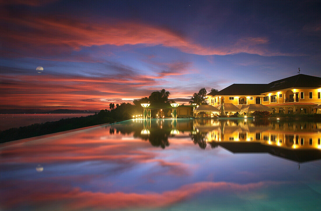 Blick über den Infinity Pool auf das Peacock Garden Resort am Abend, Baclayon, Bohol, Philippinen, Asien