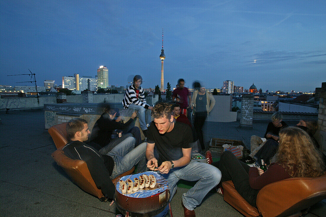 Rooftop party, young people, Prenzlauer Berg with view of night skyline, TV tower, Berlin, Germany