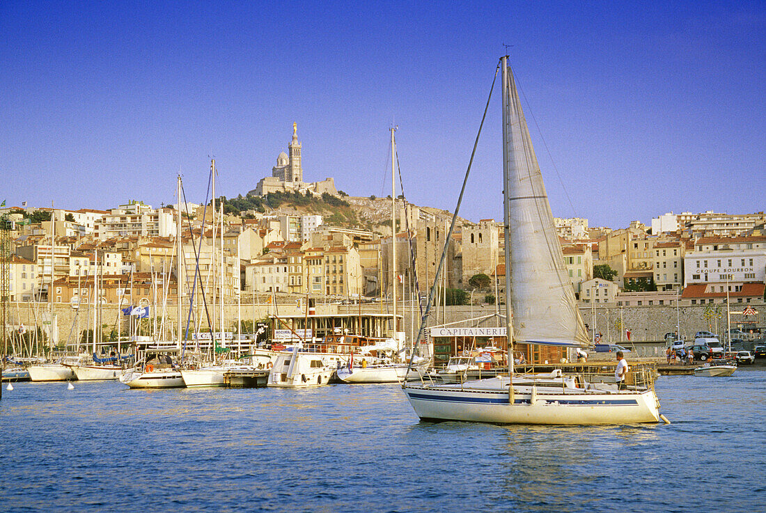 Sailing boats at Vieux Port harbour in front of church Notre-Dame-de-la-Garde, Marseille, Provence, France, Europe