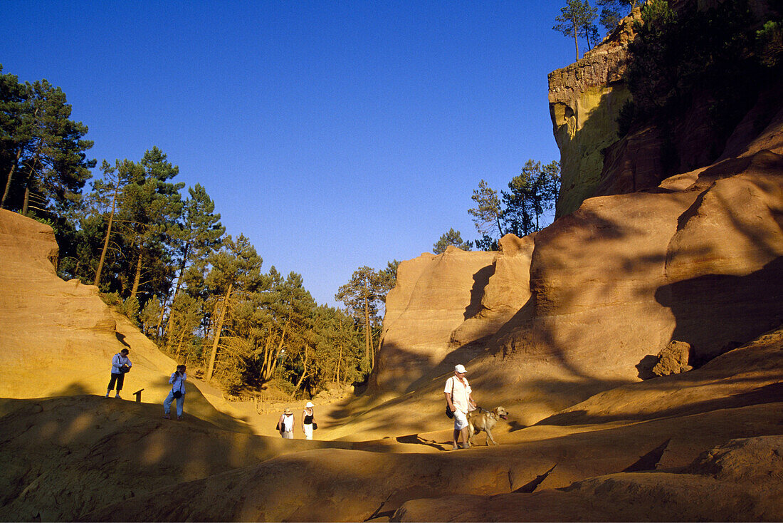 Menschen an den Ockerfelsen im Val de Fées unter blauem Himmel, Vaucluse, Provence, Frankreich, Europa