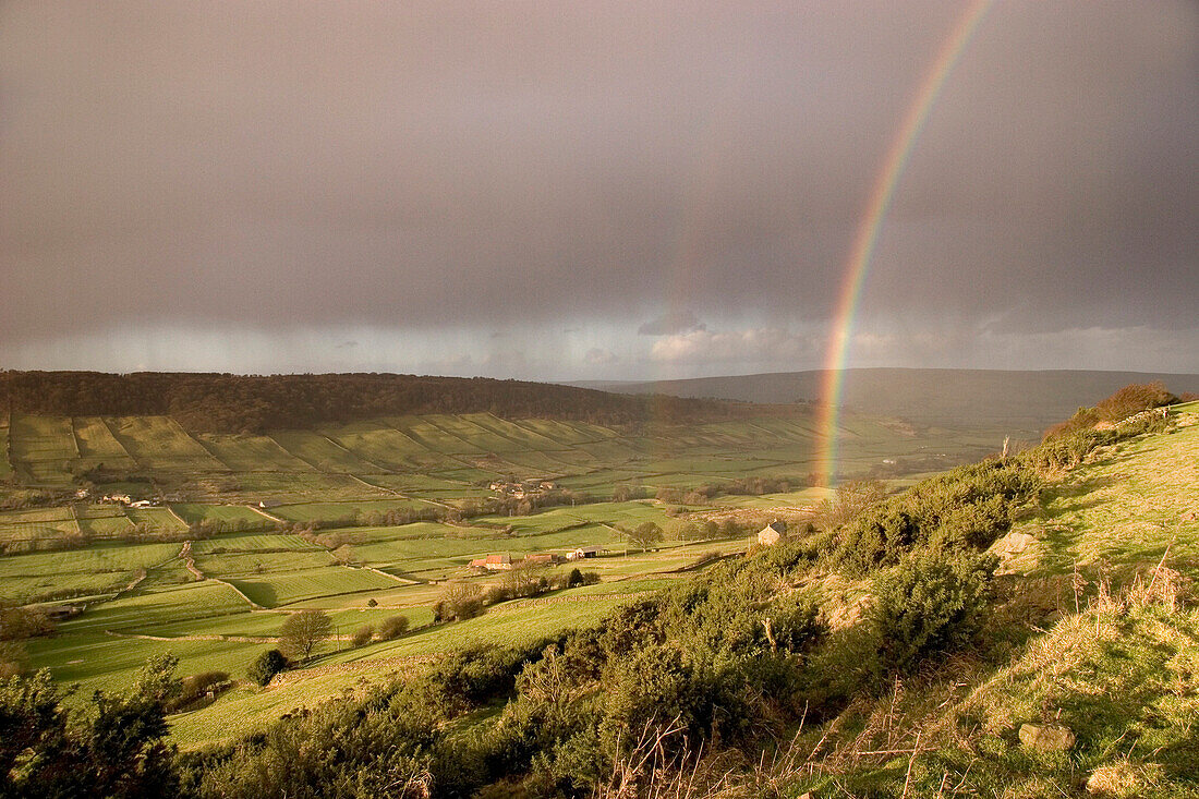 View over moorland in winter rainstorm with rainbow, Great Fryupdale, Yorkshire, UK, England