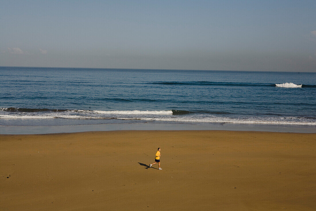 Einsamer Jogger am Strand, Playa de las Canteras, Las Palmas de Gran Canaria, Gran Canaria, Kanarische Inseln, Spanien, Europa