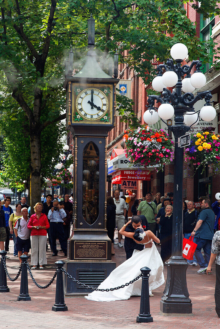 Hochzeitspaar kuesst sich vor der Dampfuhr in Gastown, Vancouver, Kanada, Britisch Kolumbien, Nordamerika