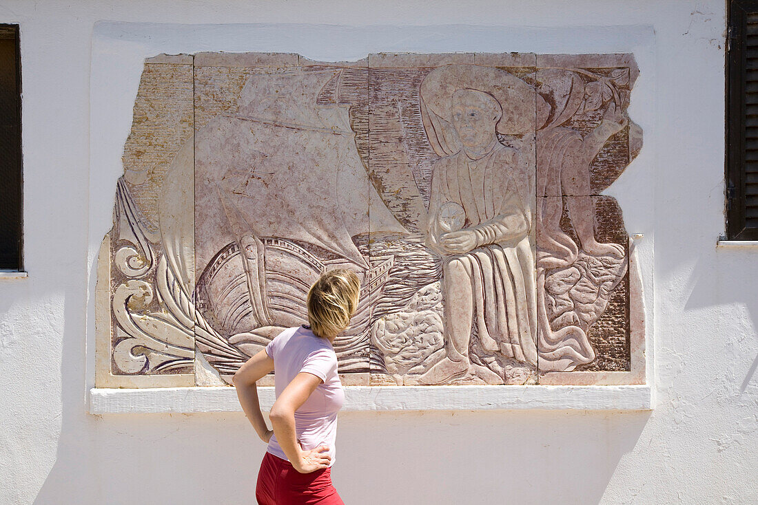 Junge Frau betrachtet den Wandbild von Heinrich dem Seefahrer (15. Jh.), MR, Westkueste der Algarve, Sagres, Algarve, Portugal