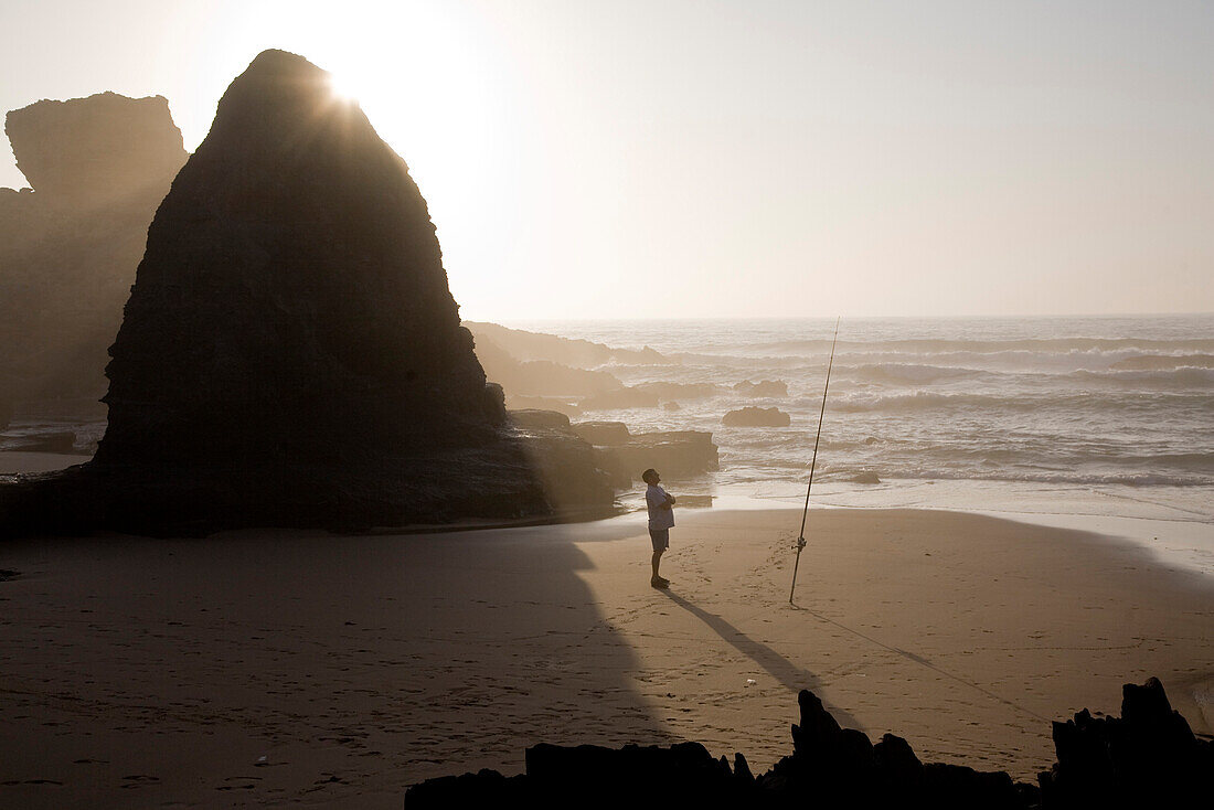 Fischer am Strand Praia do Castelejo bei Sonnenuntergang, Angel, Vila do Bispo, Algarve, Portugal