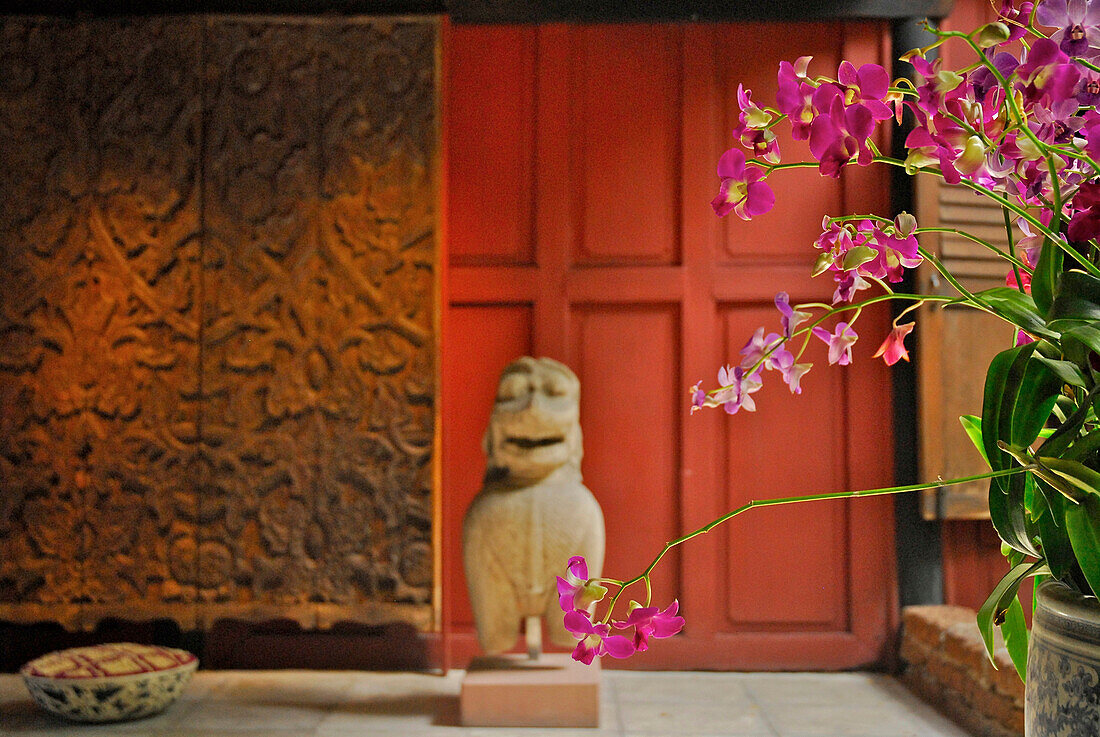 Orchideen vor Sammlerstücken im Untergeschoß, Jim Thompson House, Museum, Bangkok, Thailand, Asien