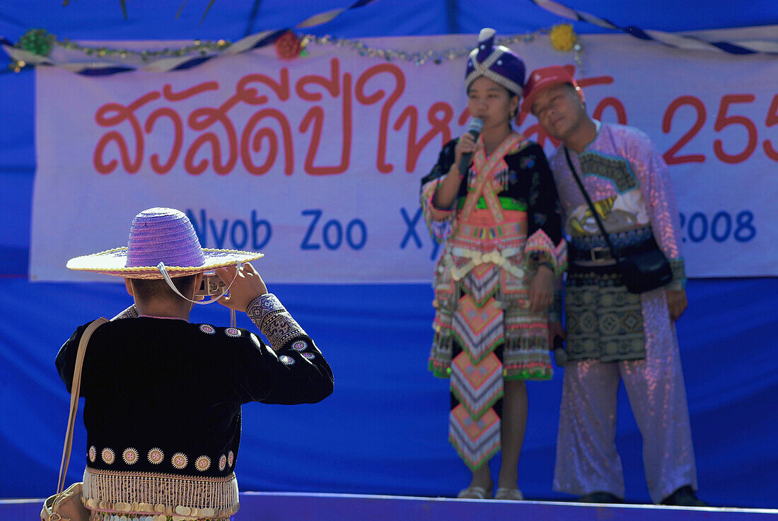 Hmong man fotografiert Hmong Paar auf Bühne in traditioneller Tracht zur Neujahrsfeier, Mae Rim Valley, Hmong Dorf, Provinz Chiang Mai, Thailand, Asien