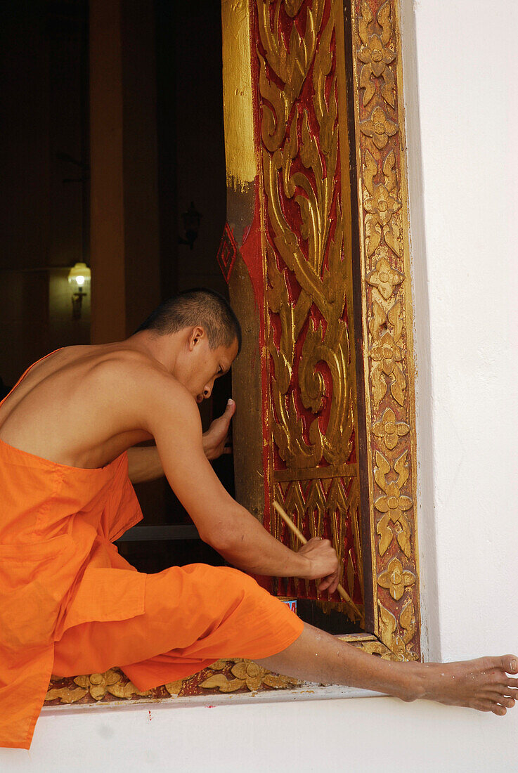 Monk painting decorations on the window frame, Restauration works at Wat Phra Si Ratana, Si Satchanalai Chalieng Historical Park, Province Sukothai, Thailand, Asia