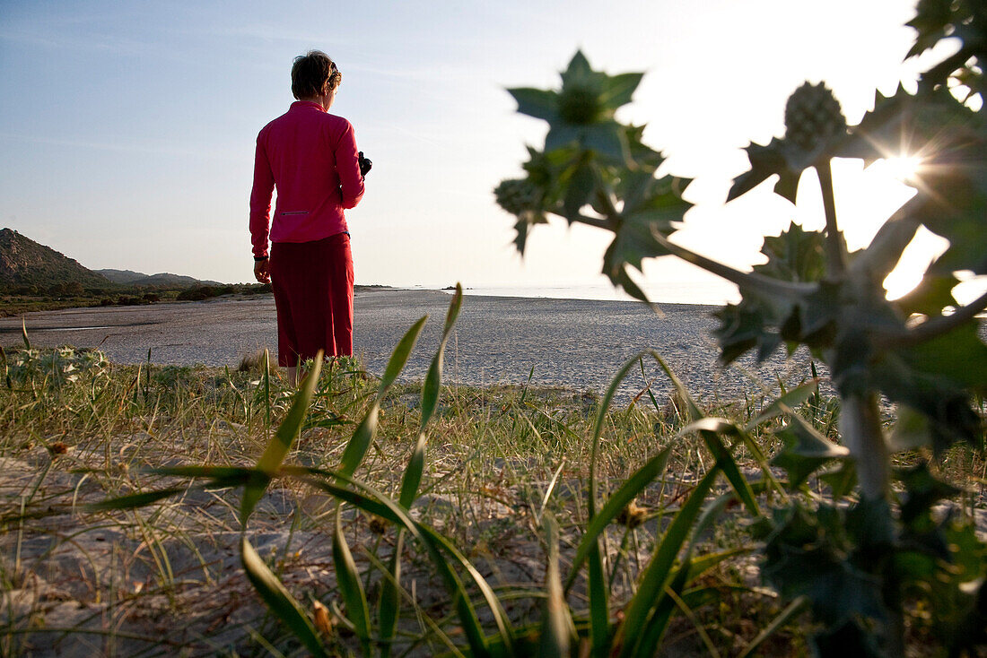 Frau mittleren Alters am Strand von Berchidda im Sonnenlicht, Berchidda, Siniscola, Sardinien, Italien, Europa