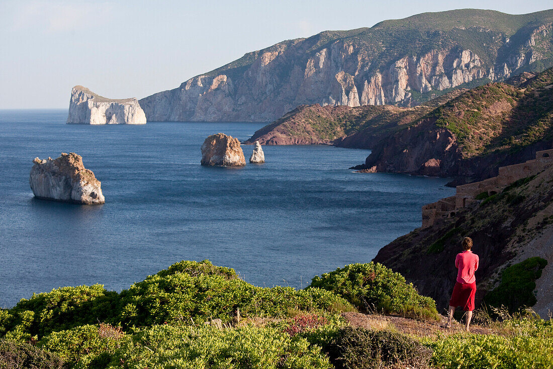 Pan di Zucchero, Frau blickt auf Felsen vor der Küste, Masua, Sardinien, Italien, Europa