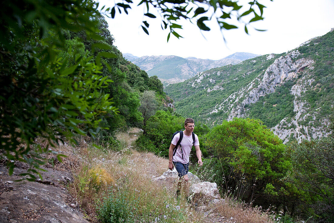 Young man on a hiking trail in the mountains, Punta de Michele, Sardinia, Italy, Europe