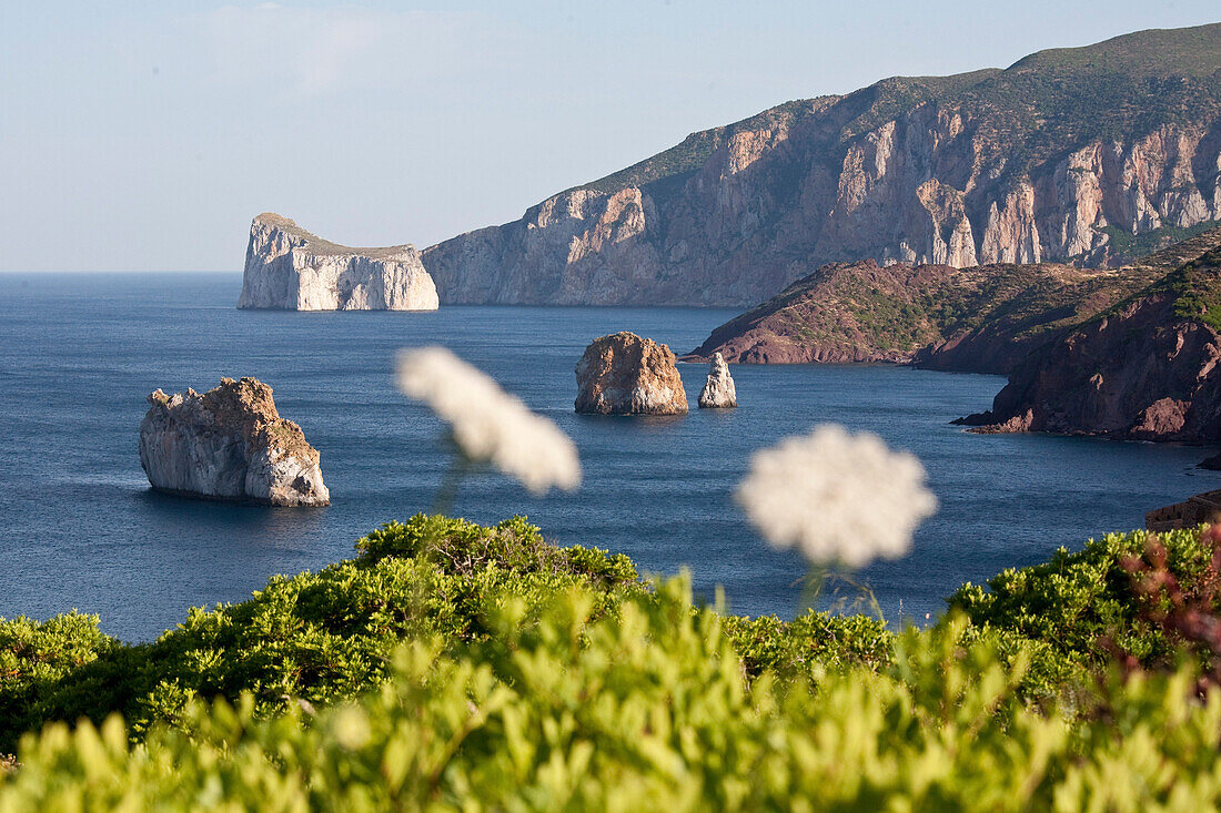 Pan di Zucchero, rocks off shore in the sunlight, Masua, Sardinia, Italy, Europe