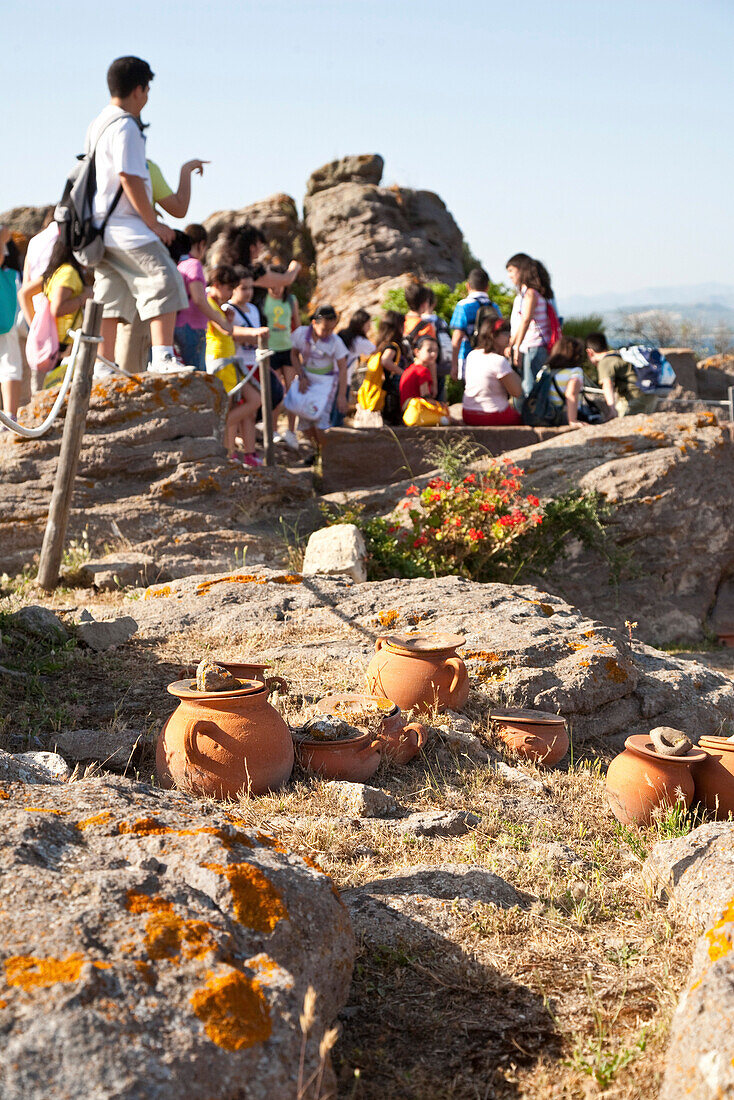 Tonkrüge und Touristen auf Felsen im Sonnenlicht, Museum über das antike Sulki, Sant'Antioco, Sardinien, Italien, Europa