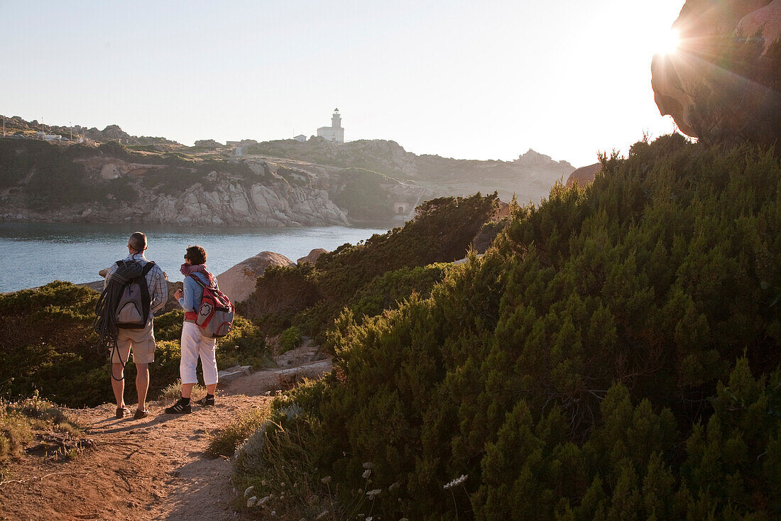 Hikers on a hiking trail on shore in the evening light, Capo Testa, Santa Teresa Gallura, Sardinia, Italy, Europe