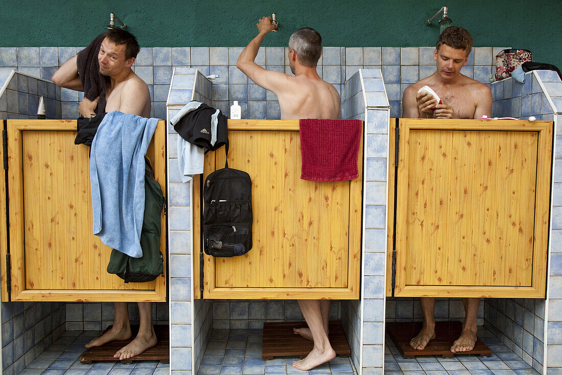 Drei Männer in der Dusche auf einem Zeltplatz, Sachsen, Deutschland, Europa