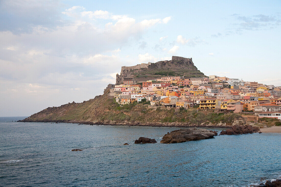 Blick auf bunte Häuser und eine Burg an der Küste, Castelsardo, Sardinien, Italien, Europa