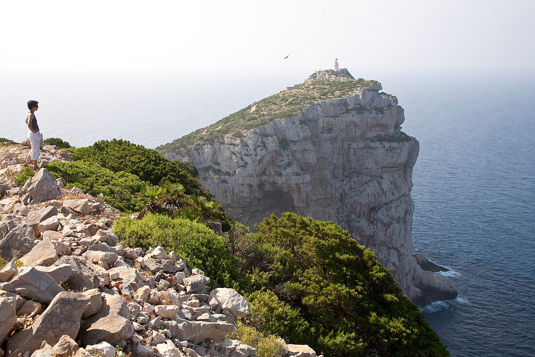 Woman standing above Capo Caccia at a steep coast, Alghero, Sardinia, Italy, Europe