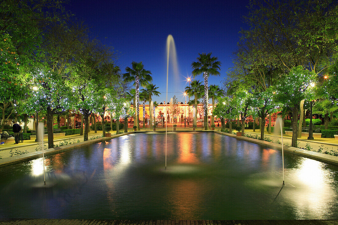 Prado de San Sebastian, tree-lined lake with fountains at night, Seville, Andalucia, Spain