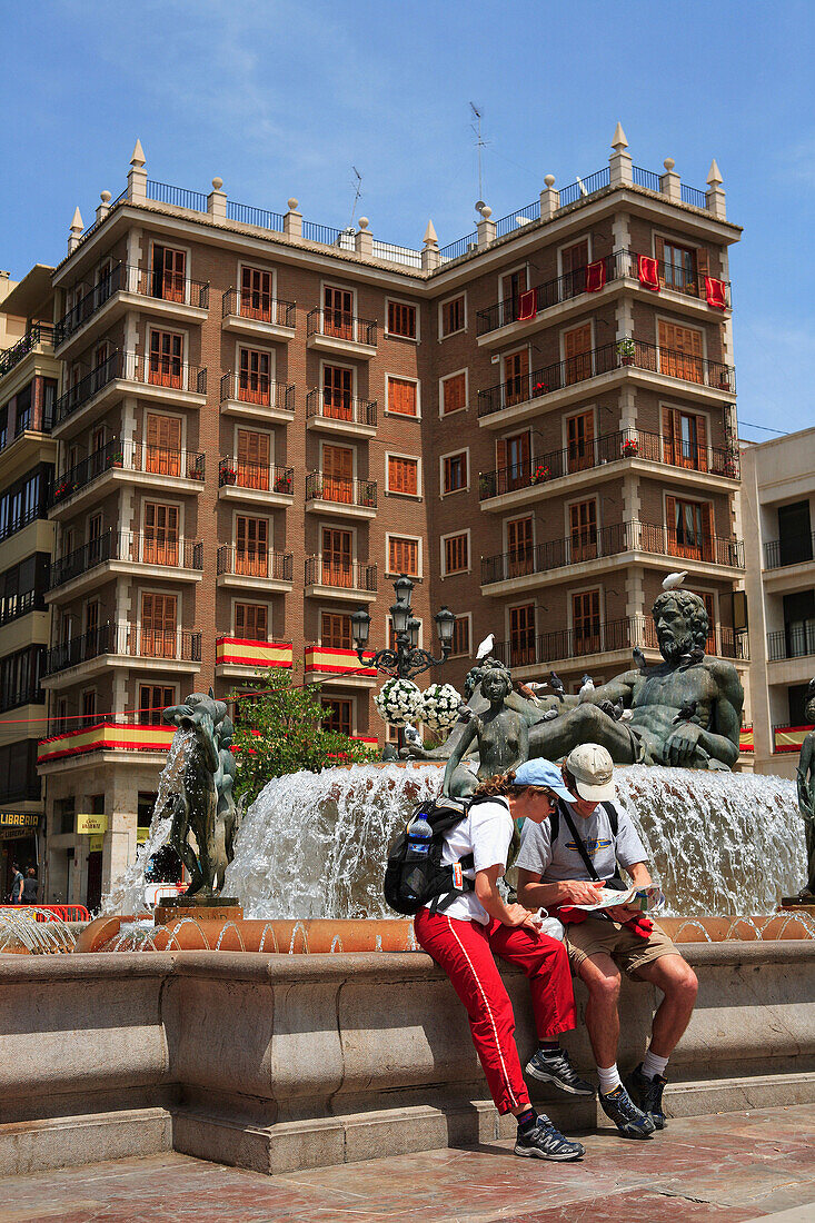 Plaza de la Virgen, tourists reading map on steps of fountain, Valencia, Valencia Region, Spain