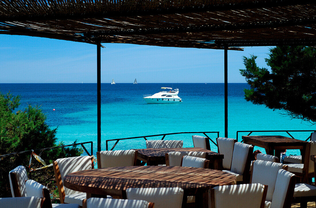 View from cafe terrace of bay with boats, Liscia di Vacca, Sardinia, Italy