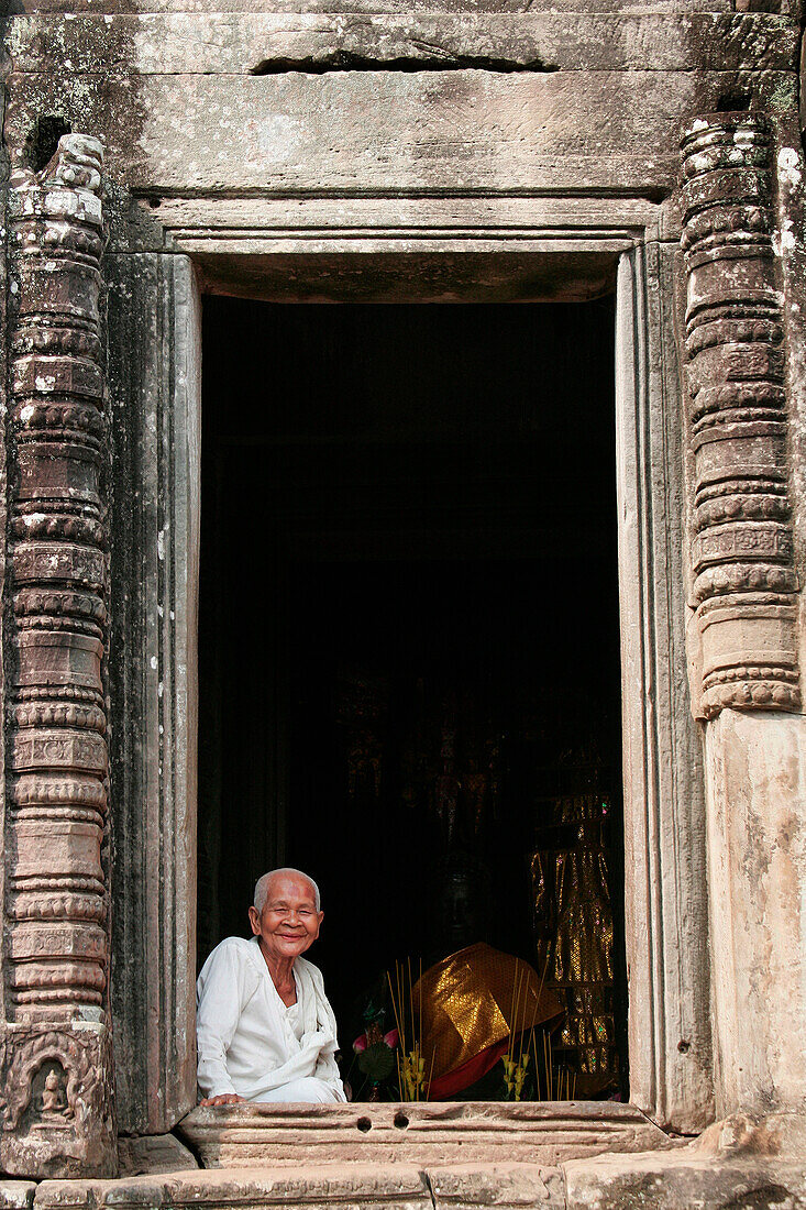 Angkor Thom, smiling Buddhist nun at window of the Bayon temple, Siem Reap, near, Cambodia