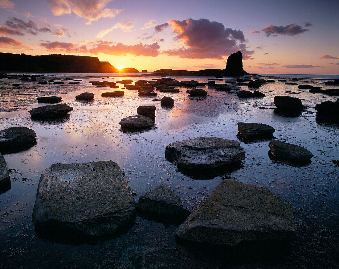 Black Nab rock at low tide at sunset, Saltwick Bay, Yorkshire, UK, England
