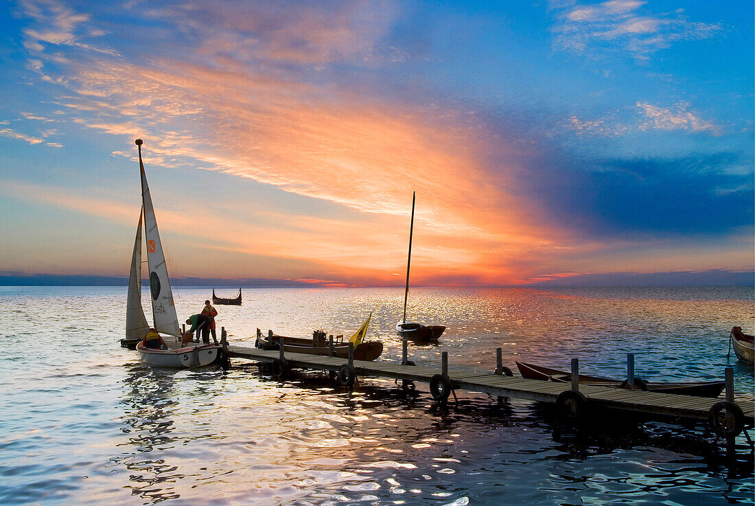 Lake scene with boats at jetty at sunset, Olsztyn, Poland