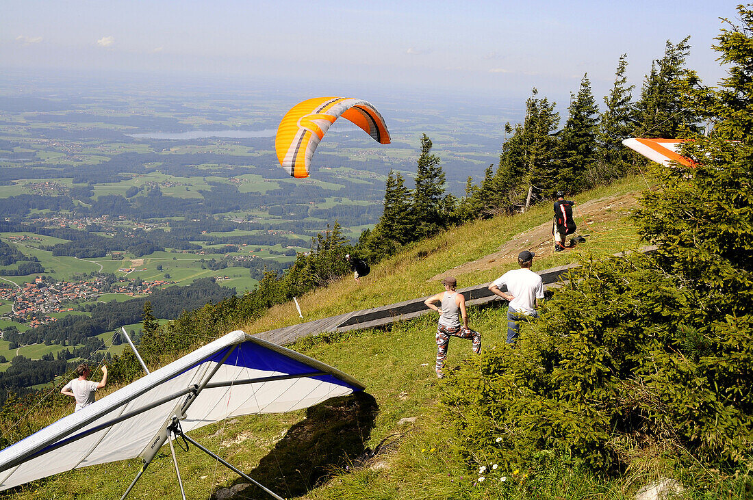 Paraglider preparing for take-off, Hochries, Chiemgau, Bavaria, Germany