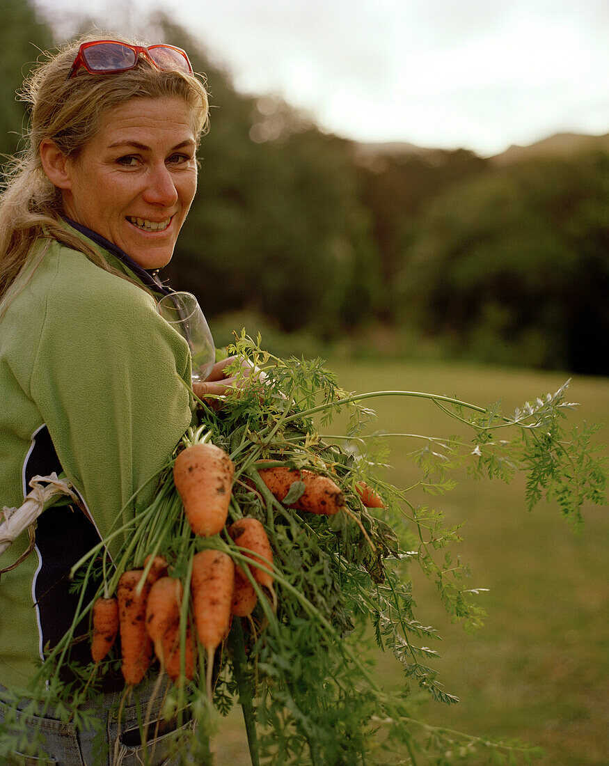 Farmerin Angela Thacker mit frisch geernteten Karotten, Rowendale Homestead, Okains Bay, Banks Peninsula, Südinsel, Neuseeland
