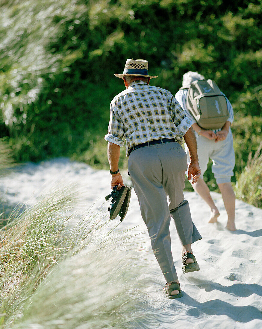 Altes Paar wandert über eine Düne zum Wharariki Beach, Nordwestküste, Südinsel, Neuseeland