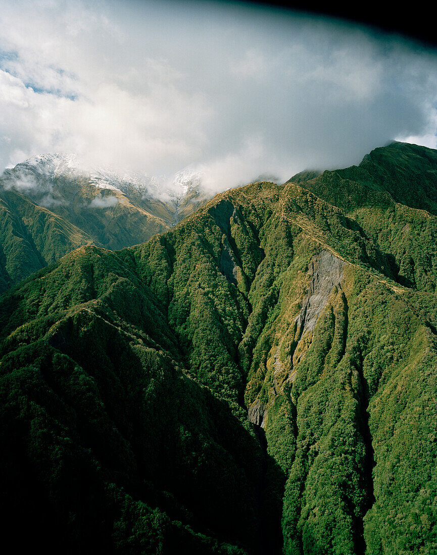 Luftaufnahme der Berghänge im Westland Nationalpark unter Wolken, Südinsel, Neuseeland