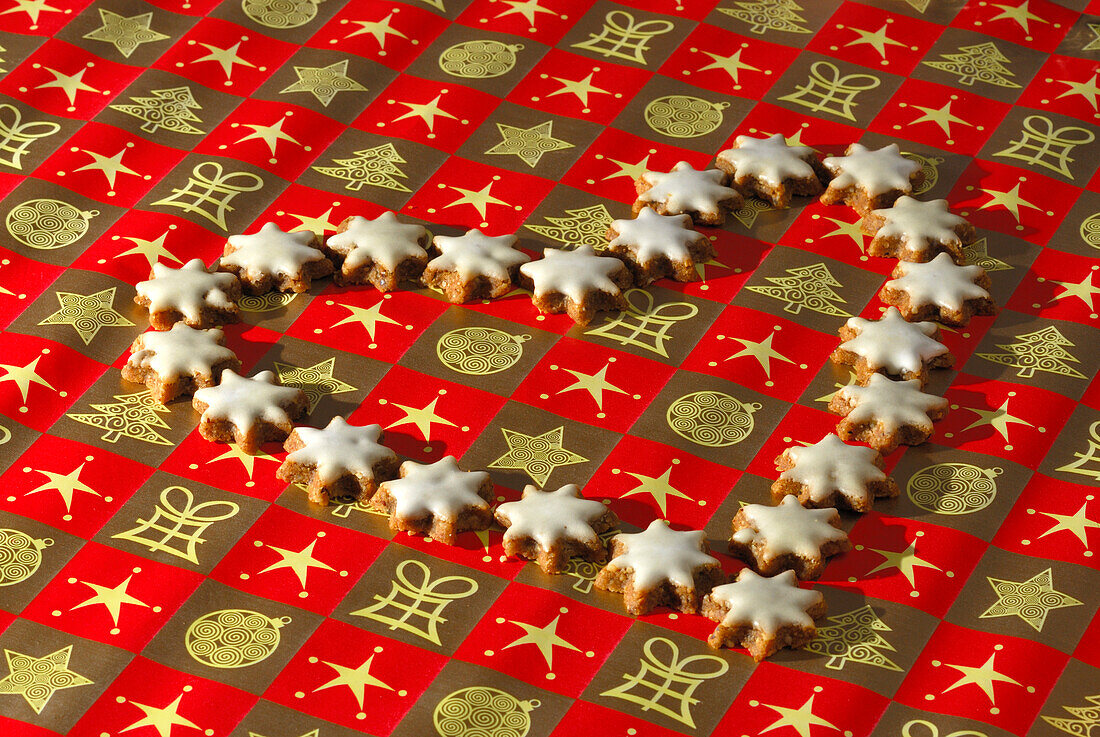Christmas cookies cinnamon stars laying in heart shape on wrapping paper